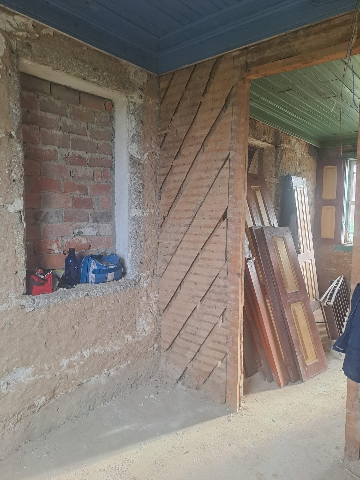 Old interior doors pulled and stacked in a corner