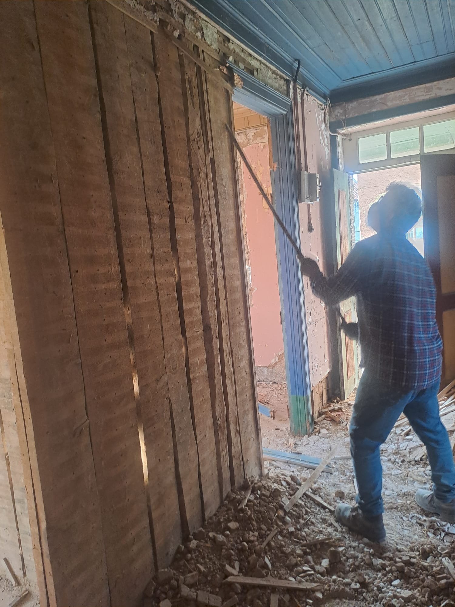 Prying an old door frame loose from the wall