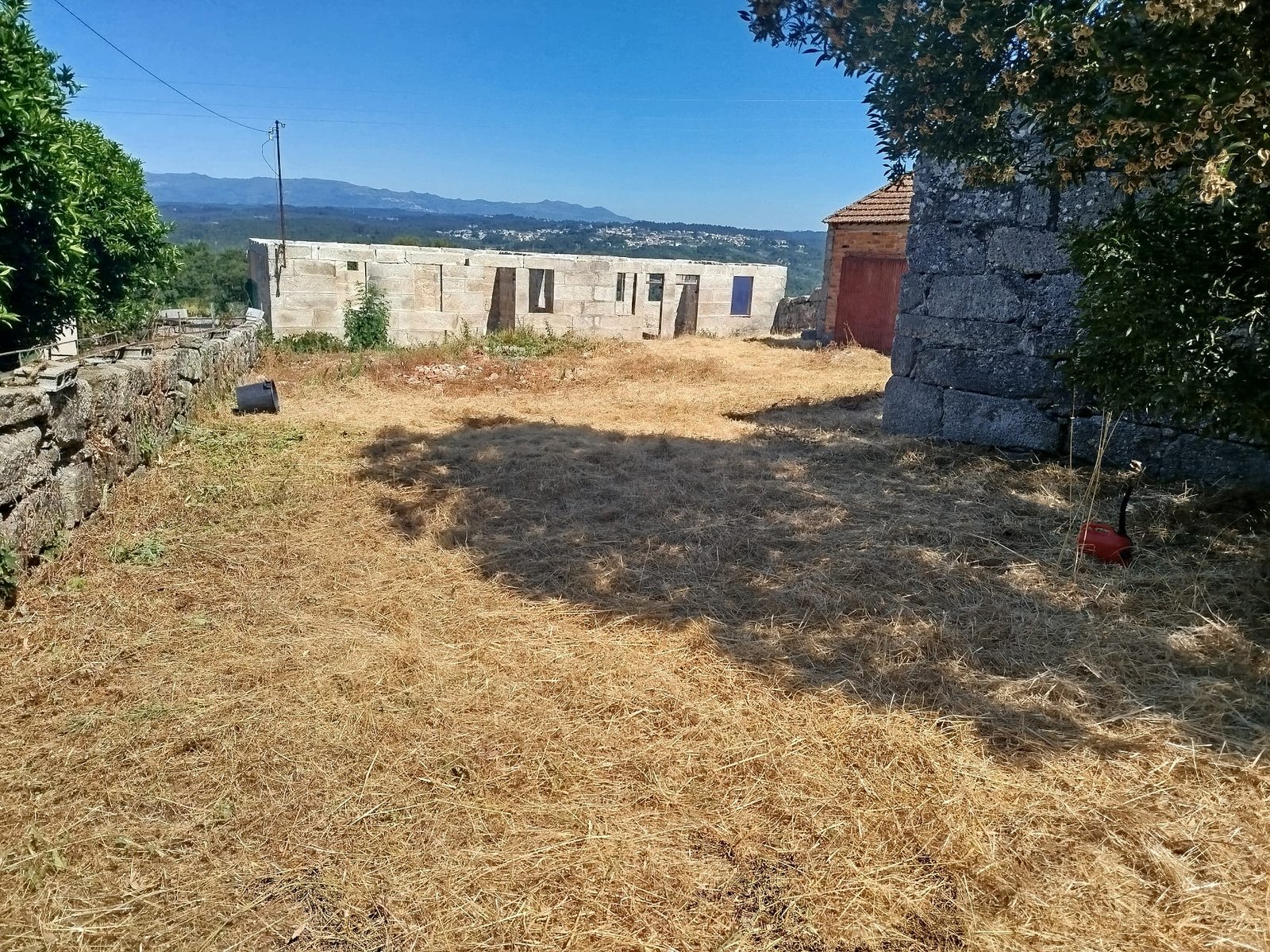 The front of the house after demolition, cinder block walls up and cleared yard