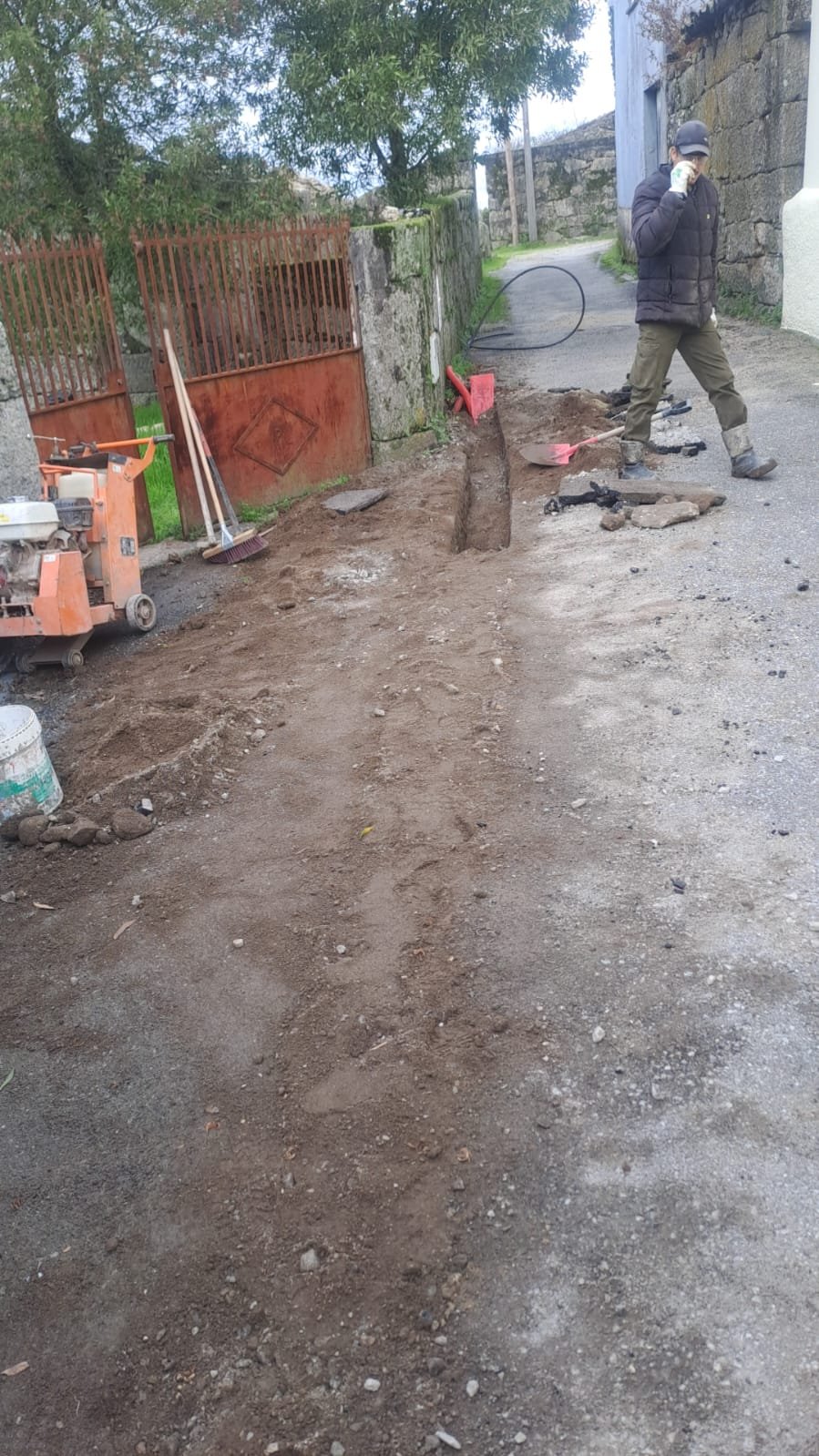 A trench cut along the lane for the electrical conduit run